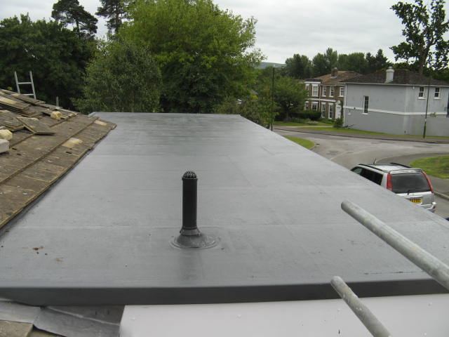 Newly finished flat roof with a vent pipe, seen from the scaffold