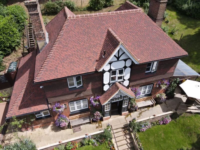 Aerial view of a newly tiled clay roof on a Tudor-style house