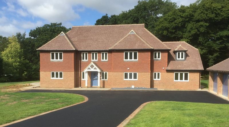 Large new-build house with a clay tiled roof and tile-hung upper walls