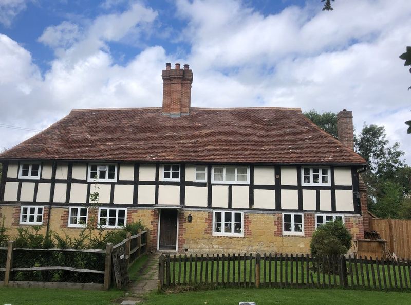Black-and-white timber-framed cottage with a reclaimed clay tile roof